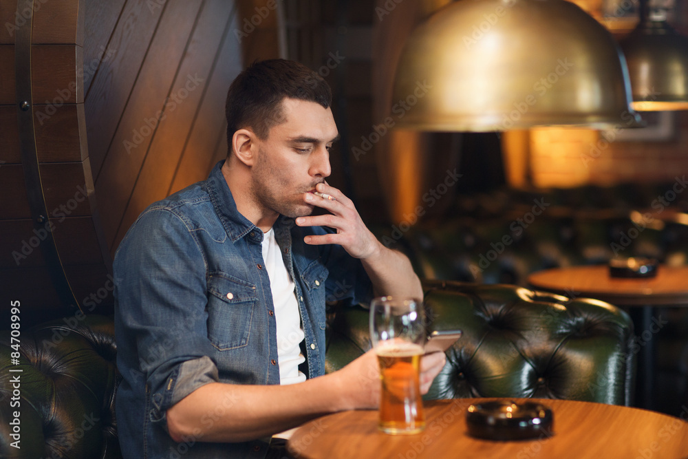 man drinking beer and smoking cigarette at bar Stock Photo | Adobe Stock