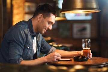 Poster - man with smartphone and beer texting at bar