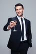 © Drobot Dean - Happy businessman holding glass of champagne