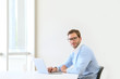 © goodluz - Businessman in modern office working on laptop