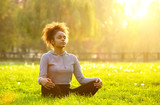 Fototapeta  - African american woman meditating in nature