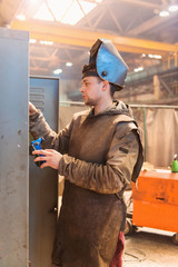 Wall Mural - Young man in a welding factory in protective workwear