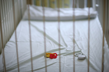 Closeup of a empty baby's crib with left toys