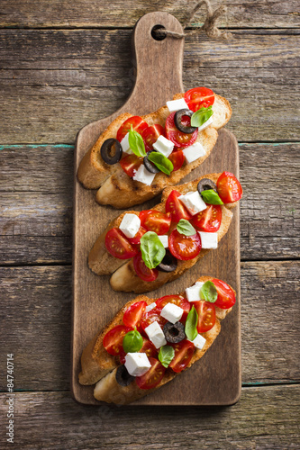 Fotografía Bruschetta con tomate, queso feta y albahaca