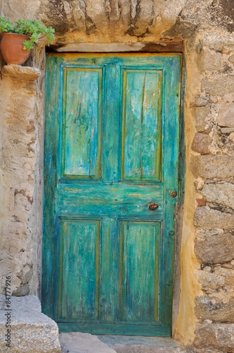 szmaragdowo-zielone-drzwi-na-kamiennej-fasadzie-w-starej-wsi
