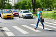 Woman crossing street at pedestrian crossing