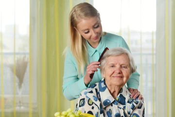 Senior woman with her caregiver in home.