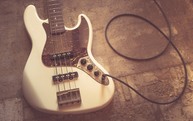 old vintage electric bass guitar on basement floor