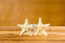 Two Wedding Rings With Two Starfish On Wooden Table