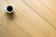 a cup of coffee resting on wooden floor