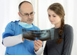 Dentist bespricht Röntgenbild mit Patient