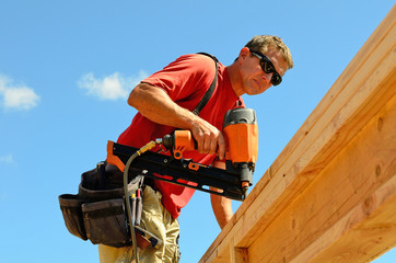 Building contractor worker with a air nail gun  