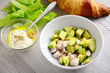 Chicken avocado salad with light yogurt dressing on gray wooden table