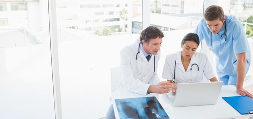 Team of doctors working on laptop computer 