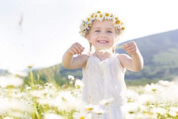 Wall Mural - Cute little girl in the chamomile field