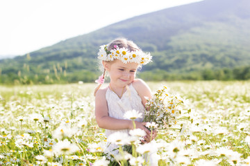 Wall Mural - Smiling little girl with wreath of chamomiles