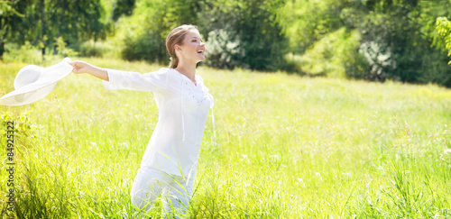 Fotografia Happy Young Woman Enjoying Summer on the Green Meadow.