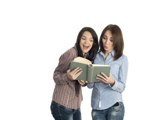 Young women read book on white background.
Image of two girls dressed in checkered red blue striped brown shirts jeans casual style keeping large old book and reading it expressing bright emotions