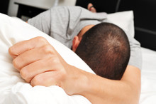 Young Man Face Down In Bed Clutching Tightly His Pillow