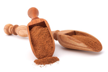 ground cinnamon spice powder in wooden spoon isolated on white b