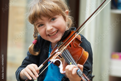 Fototapeta Portrait Of Young Girl Learning To Play Violin