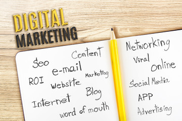 Poster - open Notebook on wooden desk with word relate with Digital Marke