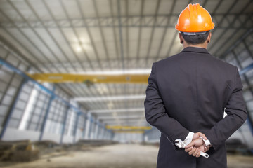 engineer holding orange helmet for workers security on factory b