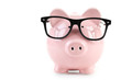 Pink piggy bank with glasses on white wooden background