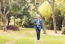 Middle Aged Woman Walking At The Park
