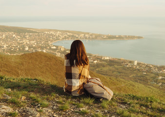 Poster - Woman wrapped in plaid resting on peak of mountain