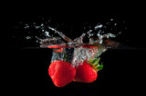 Fototapeta Kuchnia - Strawberries splashing into water