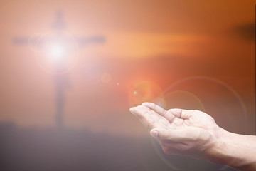 Wall Mural - Praying Hand and the cross blurred background