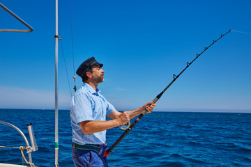 Wall Mural - Beard sailor man fishing rod trolling in saltwater