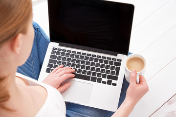 happy young woman  relaxes and  working at home at a laptop with