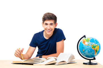 Male student sitting at the table with books