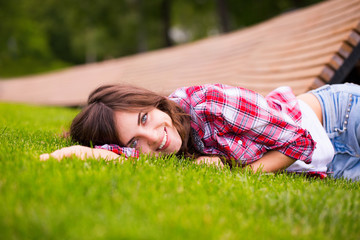 Wall Mural - beautiful girl lying on green grass.
