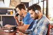 © Monkey Business - Two young men working on computers at a coffee shop