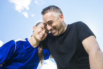 teenager girl with father play soccer