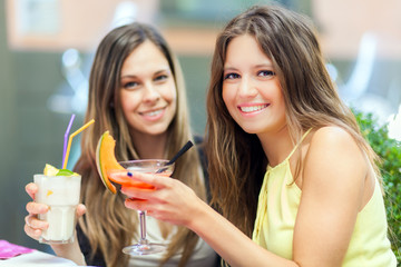 Portrait of two friends drinking a cocktail