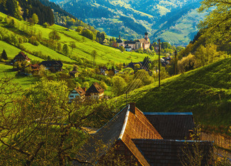 Wall Mural - Beautiful mountain landscape with a monastery in village. Germany, Black forest, Muenstertal.