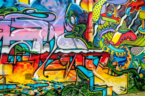Photographie Graffitis aux couleurs vives sur murs et gouttières