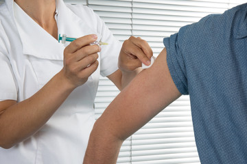 Wall Mural - A man is getting an injection with a syringe at hospital