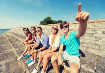 Poster - group of smiling friends sitting on city street