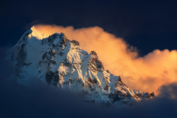 Wall Mural - mountain peak visible high in the sky in the clouds.