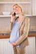 © WavebreakmediaMicro - A smiling blonde pregnancy phoning