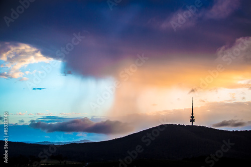 Rain clouds accumulated behind the Black Mountain in Canberra, Australia in the Poster