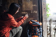 © Westend61 - Austria, Altenmarkt-Zauchensee, young female hiker carving her name in wooden door of Alpine Cabin