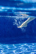 © Westend61 - Spain, woman's foot moving underwater in a swimming pool