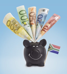 Various european banknotes in a happy piggybank of South Africa.