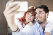 © Westend61 - Couple in kitchen taking a selfie